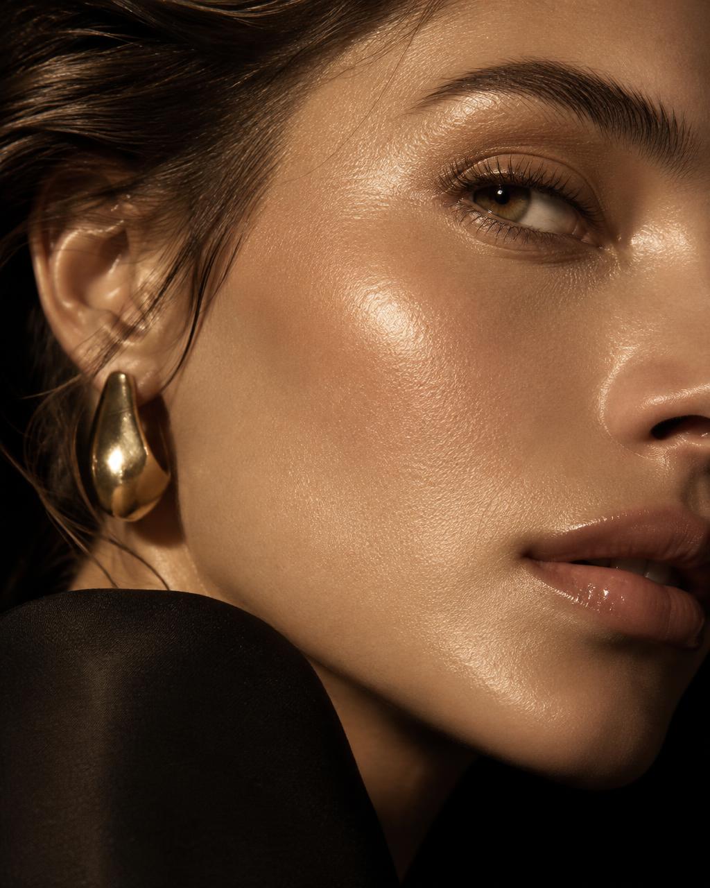 Close up of dewy radiant cheek skin in golden light